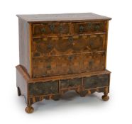 A William and Mary oyster olivewood and kingwood walnut chest on stand,the top inset with five