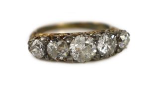 An early 20th century 18ct gold and graduated five stone diamond set half hoop ring,with carved