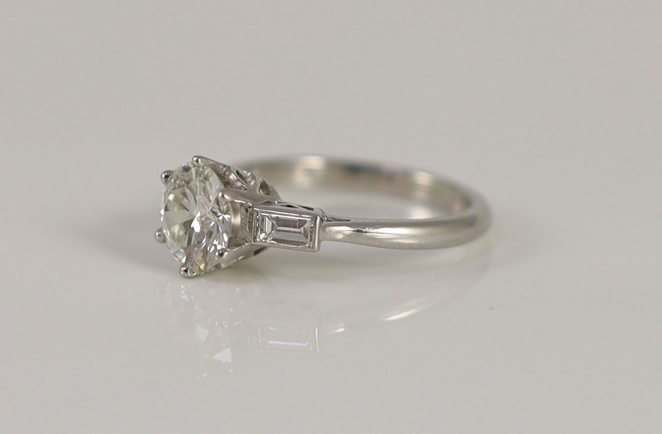 A platinum and single stone diamond ring, with baguette cut diamond set shoulders,the central - Image 2 of 4