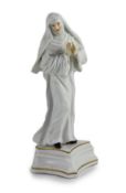 A Meissen figure of a Benedictine nun, c.1741,modelled by Kändler, standing praying, in the white
