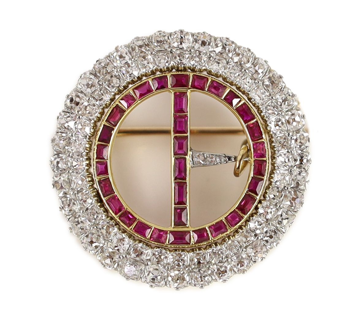 A 20th century gold and platinum, ruby and diamond set openwork circular 'buckle' brooch,with safety