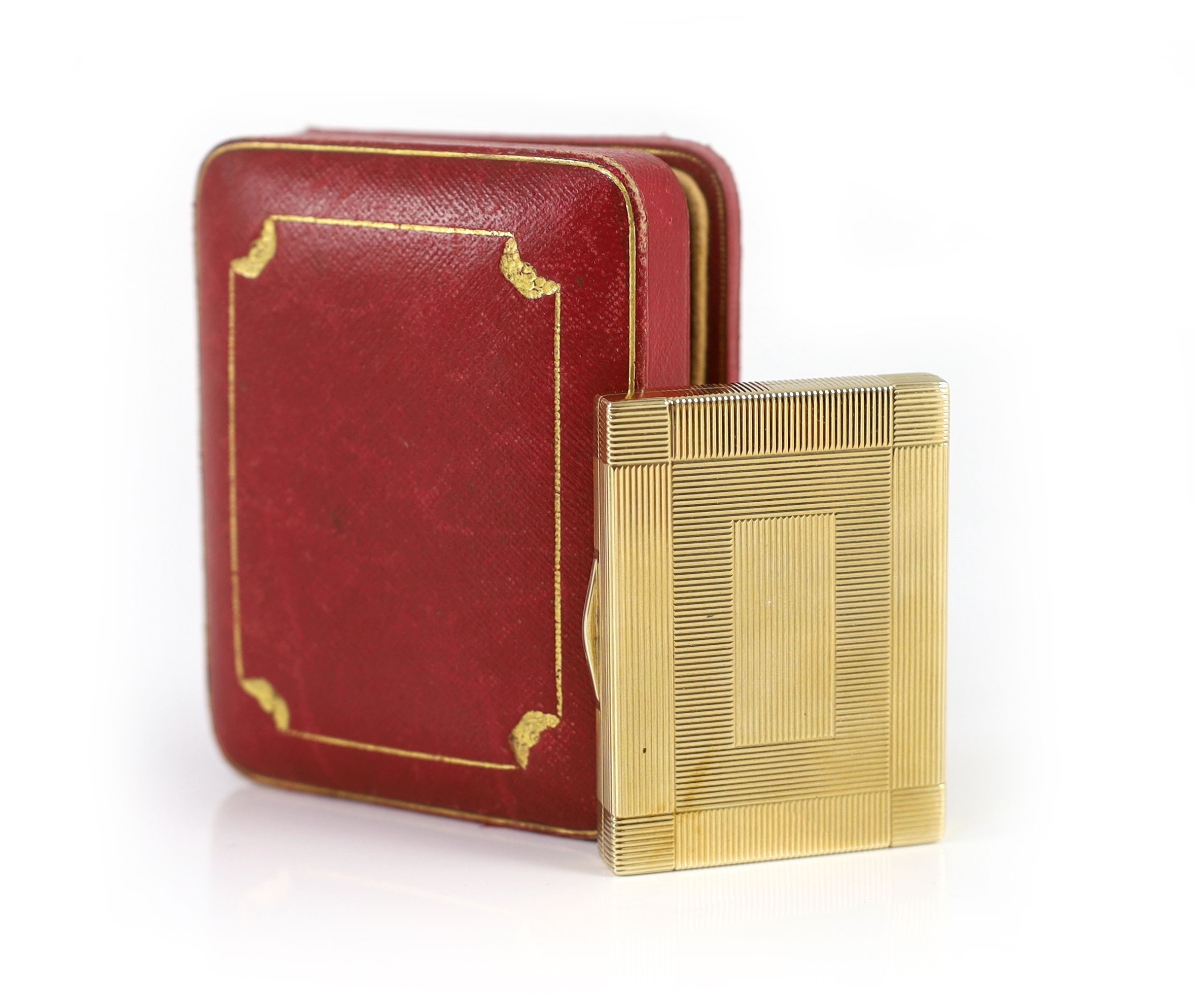 A 1930's Cartier 9ct gold compact, with diamond set thumbpiece,with reeded decoration and handled