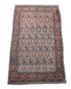 A Kerman rug ivory ground carpet,woven with rows of floral boteh within a triple floral border360