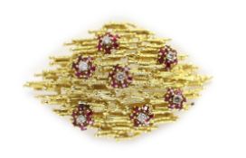 A 1970's textured gold, ruby and diamond cluster set modernist pendant brooch, in the manner of