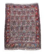 A Southern Persian ivory ground rug,woven with rows of hooked devices with a wide floral border175 x