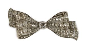 An early to mid 20th century white gold and graduated diamond cluster millegrain set ribbon bow