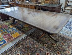 A reproduction mahogany twin pillar extending dining table together with twelve Georgian style