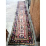 A Caucasian design brick red ground runner, 430 x 80cm