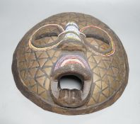 Two Japanese carved wood masks, an African beaded mask and three similar rattles