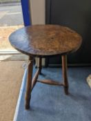 A circular burr elm and ash primitive cricket table with T shaped stretcher, diameter 44cm, height