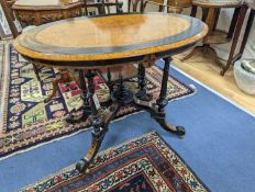A late Victorian part ebonised oval Amboyna centre table, width 90cm, depth 60cm, height 69cm
