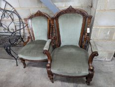 A pair of late Victorian carved walnut salon chairs upholstered in green dralon, one with arms