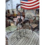 A pair of weathered metal heron garden ornaments, larger 108cm high