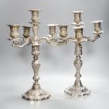 A pair of plated embossed three branch candelabra, 43cm