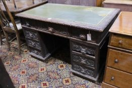 A late Victorian carved oak pedestal desk, length 121cm, depth 70cm, height 75cm