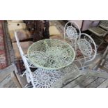 A wrought iron circular garden table, diameter 65cm, height 74cm and four folding chairs