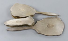 A silver three piece brush and mirror set.