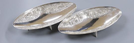 A pair of Indian sterling oval dishes, embossed with figures and elephants, 24.9cm, 18.5oz.