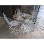 A circular painted wrought iron garden table, diameter 75cm, height 75cm together with four