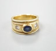 A modern yellow metal and collet set sapphire and diamond three stone ring, signed Charles Greig,