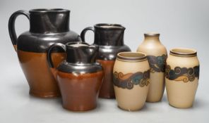 A graduated set of three Bourne Denby stoneware jugs and three 1930's stoneware vases, by