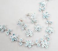 A modern 925 and blue zircon suite of jewellery, comprising a flower head cluster necklace and a