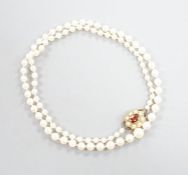 A single strand graduated cultured pearl necklace, with 9ct, garnet and cultured pearl cluster set