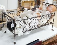 3 Armand Marseille bisque head dolls with sleeping eyes and 4 others in a wrought iron dolls crib