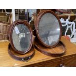 Two 19th century oval mahogany travelling toilet mirrors, larger width 36cm, height 46cm