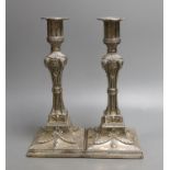 A matched pair of George III silver candlesticks, with waisted fluted stems and rams head, winged