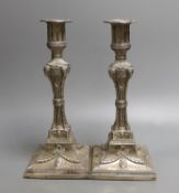 A matched pair of George III silver candlesticks, with waisted fluted stems and rams head, winged