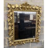 A late 19th century Florentine carved giltwood wall mirror with vineous frame width 97 cm Height 116