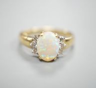 A modern 14k yellow metal, oval white opal and six stone diamond set cluster ring, size N, gross