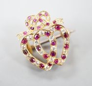 An early 20th century yellow metal, ruby and diamond set twin hearts brooch, with ribbon bow