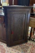 A George III later carved oak hanging corner cabinet, width 72cm, depth 42cm, height 105cm