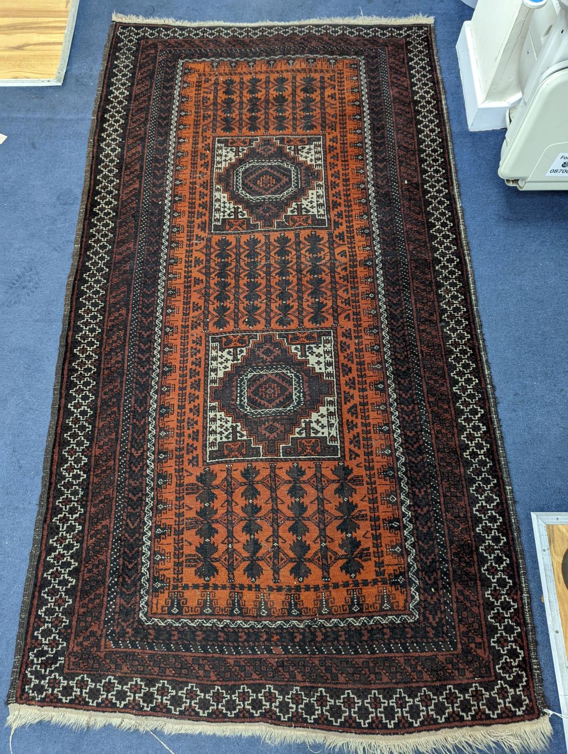 A Belouch red ground rug, 210 x 114cm