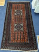 A Belouch red ground rug, 210 x 114cm