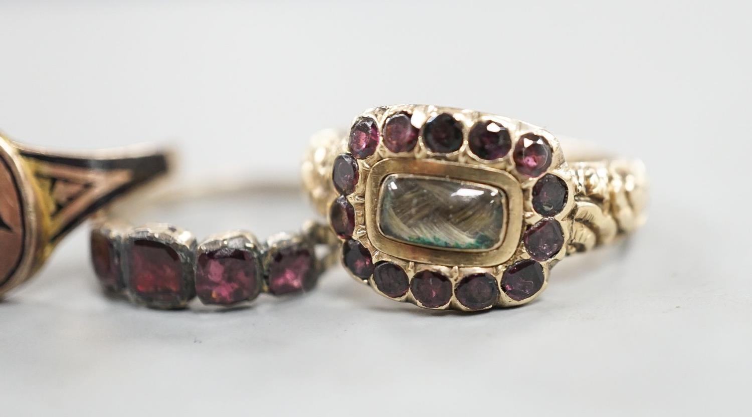 A late George III yellow metal, garnet and plaited hair mounted mourning ring, inscribed 'Ann - Image 2 of 8