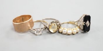 A 9ct gold wedding band, 4.8 grams, a yellow metal and split pearl set half hoop ring, a black