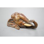 A small bronze elephant paperweight, ivory tusks,9 cms long.