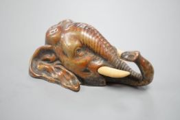 A small bronze elephant paperweight, ivory tusks,9 cms long.