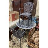 A circular painted aluminium garden table and three elbow chairs