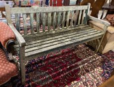 A weathered teak garden bench, length 153cm, depth 52cm, height 83cm