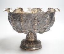 A late 19th century Burmese embossed white metal pedestal bowl, with wavy border, diameter, 27.