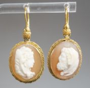 A pair of early 20th century yellow metal and oval cameo shell earrings, carved with a lady to
