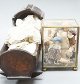 A collection of miniature bisque dolls and another larger doll in a wooden cradle, 11 dolls in