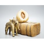 An alabaster fruit carving, a Benin brass elephant and salesman's model of a bale of Drysdale