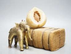 An alabaster fruit carving, a Benin brass elephant and salesman's model of a bale of Drysdale