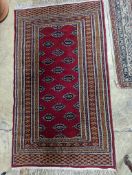 A Bokhara red ground rug, 155 x 88cm