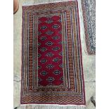 A Bokhara red ground rug, 155 x 88cm